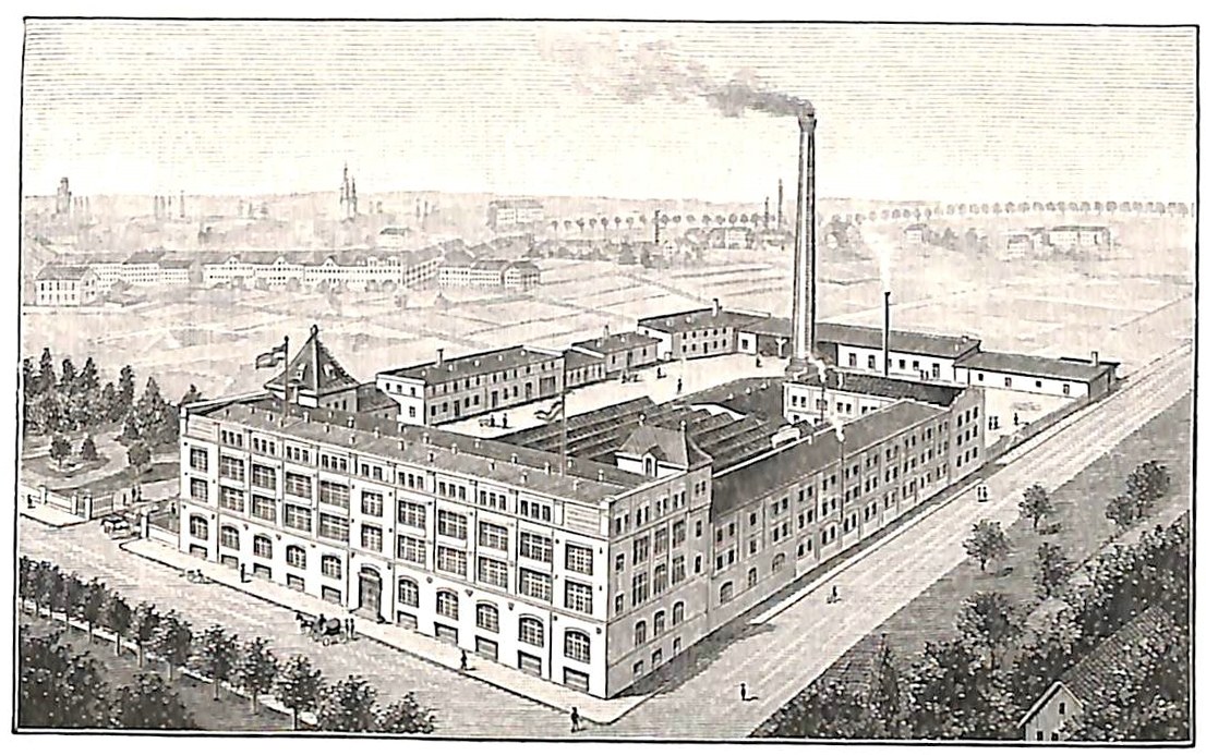 Alte Fabrik mit einem großen zentralen Gebäude umgeben von Bäumen und Text unten.