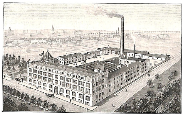 Alte Fabrik mit einem großen zentralen Gebäude umgeben von Bäumen und Text unten.