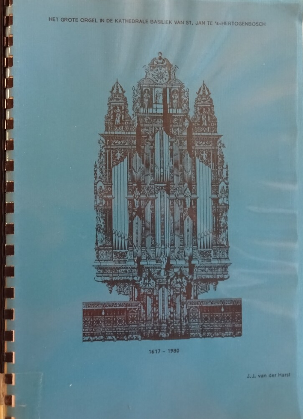 Ein Buch mit einem Umschlag, der eine Kirche mit einem hohen Turm und einem großen Glockenturm zeigt, das auf einer Oberfläche liegt.