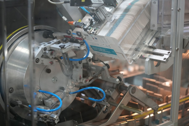 Automatisiertes Verpackungssystem-Maschine auf einem Fabriktisch mit leicht unscharfen Hintergrundobjekten.