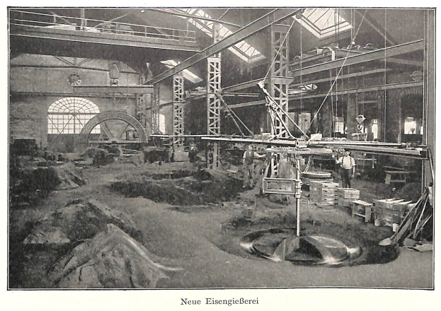 Schwarzes und weißes Foto einer deutschen Fabrik aus dem 19. Jahrhundert mit Arbeitern, die Maschinen bedienen, Metallstangen und -stöcke, beschriftet mit "Neue Eisenglebeerei, die erste Fabrik in Deutschland" unten.