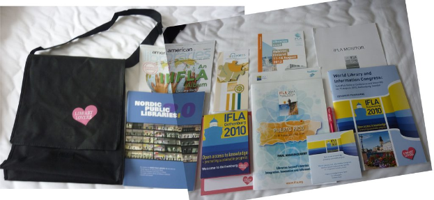 Eine Tasche mit "Bibliothek-Liebhaber" drauf und einige B├╝cher sind auf einem Bett plaziert.