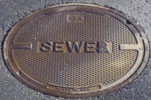 Metallschachtdurchlass auf der Straße mit der Aufschrift "Kanal"