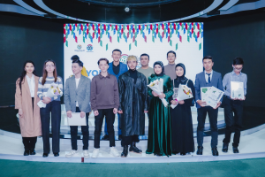 Gruppe von Menschen auf einer Bühne mit Blumensträußen und Zertifikaten, im Hintergrund ein 'Youth Solar Awards 2019'-Plakat