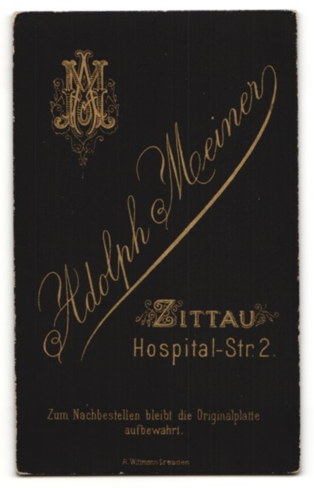 Ein schwarzes Buch mit goldenen Buchstaben auf einem weißen Hintergrund, betitelt mit 'Adolph Meiner - Zittau Hospital-Str 2'.