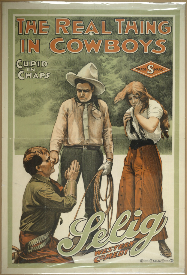 Plakat an einer Wand mit drei Personen in Cowboy-Kleidung und "The Real Thing in Cowboys" in fetter schwarzer Schrift auf einem hellgelben Hintergrund.