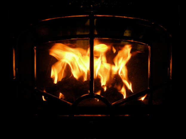 Ein Feuer brennt in einem mit Brennholz gefüllten Schornstein.