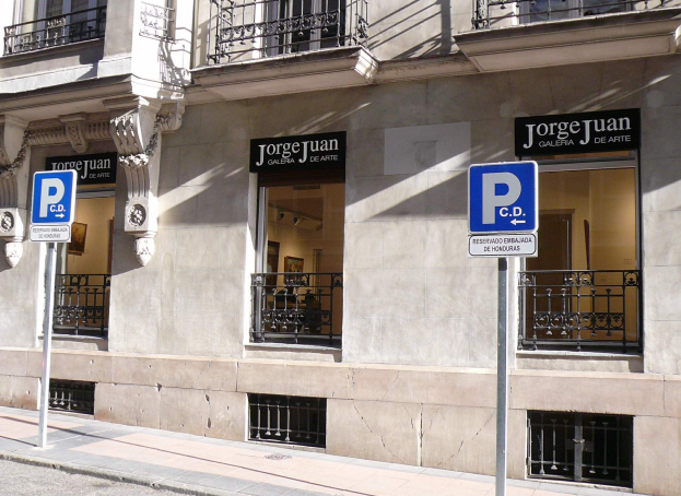 Ein mehrst├Âckiges Geb├Ąude mit Fenstern, Gel├Ąndern, Türen und S├Ąulen, das Schilder auf Pfosten an der Stra├če und sichtbare Innenobjekte zeigt, die eine belebte Stadtumgebung suggerieren.