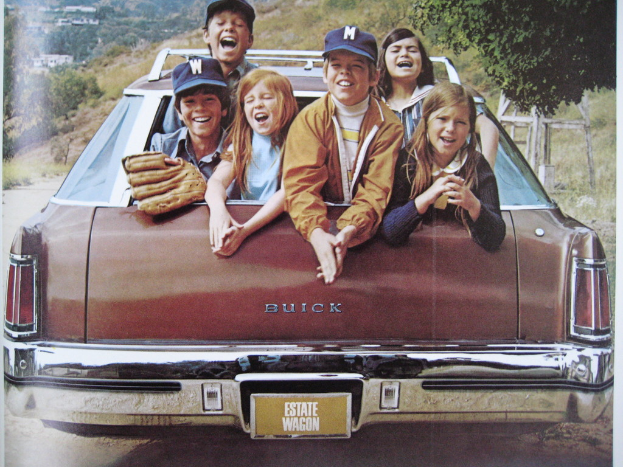 Eine Gruppe strahlender Kinder in einem Auto sitzend.