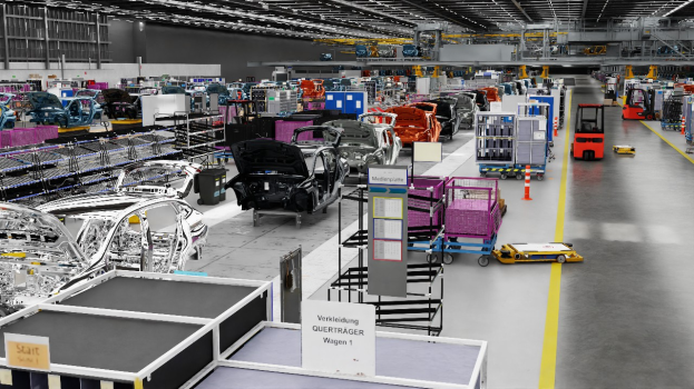 Ein großer Fabrikinnenraum mit zahlreichen Autos auf der Fertigungslinie, Metallobjekte auf beiden Seiten, einige Fahrzeuge auf dem Boden, eine Wand im Hintergrund und Deckenleuchten, wahrscheinlich ein Volkswagen-Werk in Deutschland.