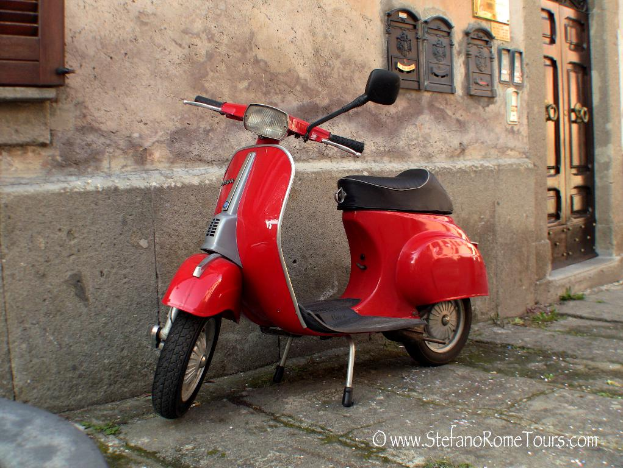 Ein roter E-Scooter steht vor einem Haus mit einer Tür und Fenstern auf einer Straße mit etwas Text unten.