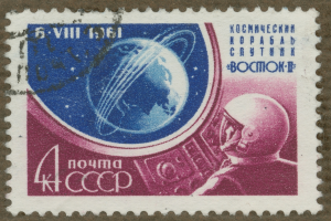 Eine Briefmarke mit einem Mann im Weltraumanzug mit entschlossener Miene, umgeben von der fett gedruckten, weißen Schrift "Marke".