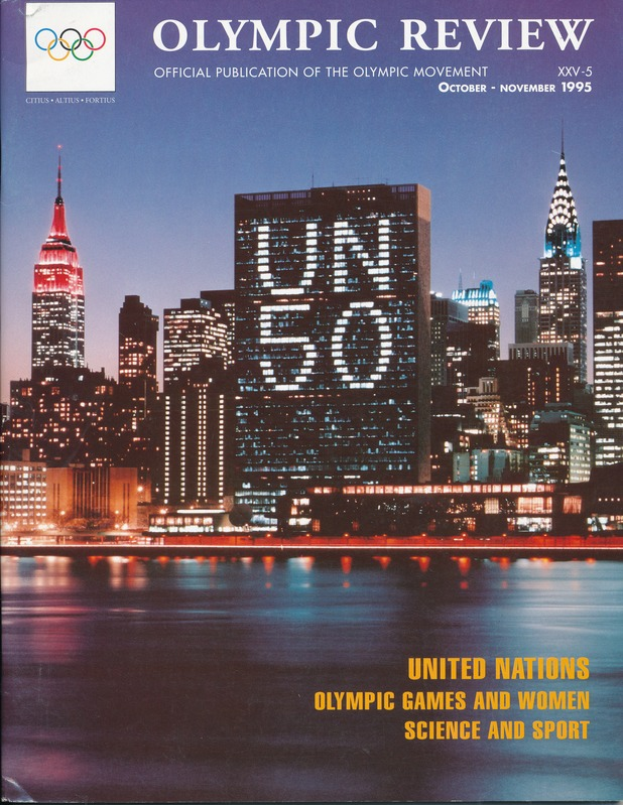 Ein Buch mit dem Titel "Olympic Review Official Publication of the Olympic Movement" liegt auf einer flachen Oberfläche und zeigt auf dem Cover eine Stadtlandschaft mit Gebäuden, Lichtern und Wasser, mit der Aufschrift "United Nations Olympic Games and Women Science and Sport".