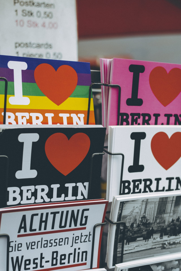 Ein Bücherregal mit Büchern und Postern, auf denen der Satz 'Ich liebe Berlin' steht, vor einem sanft unscharfen Hintergrund.