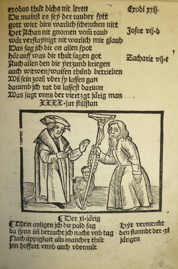 Ein Blatt mit gedrucktem Text in einer fremden Sprache, im Hintergrund stehen zwei Männer, möglicherweise aus einem Lehrbuch.