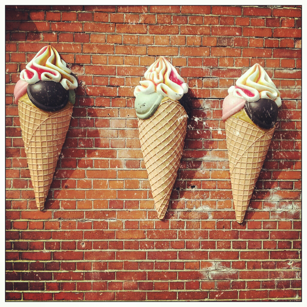 Verschiedene Eiskrem-Königs und -Becher sind an einer Wand angebracht.
